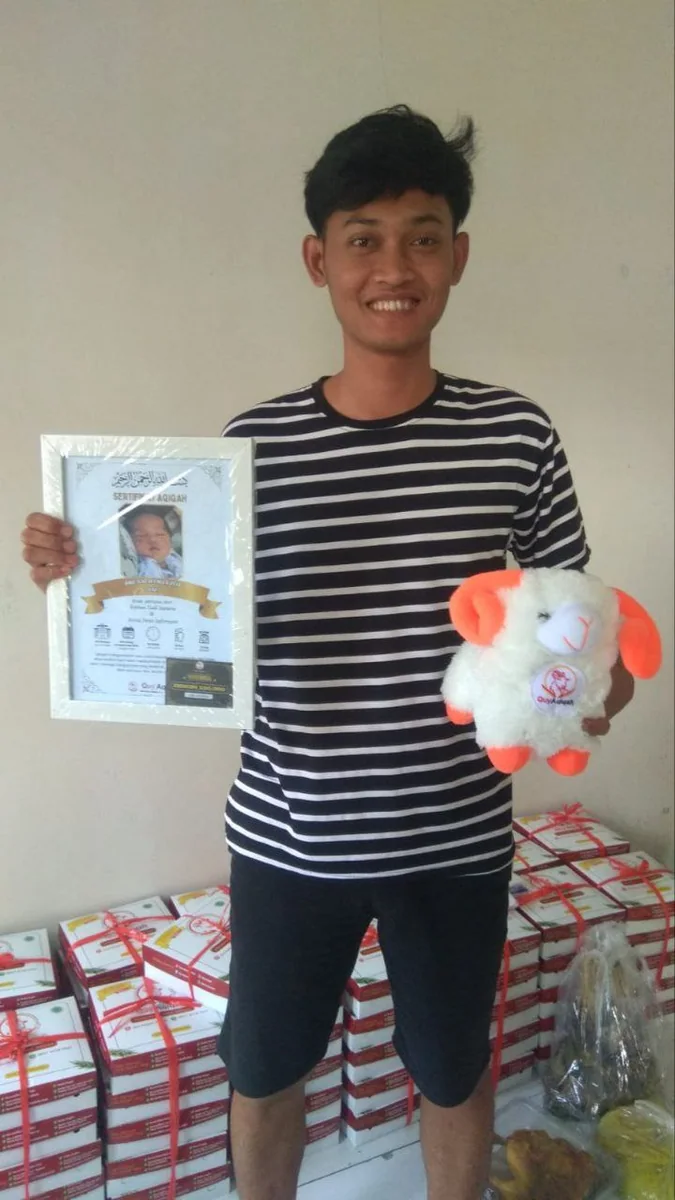 Pelanggan Quy memegang sertifikat dan boneka di depan box pesanan